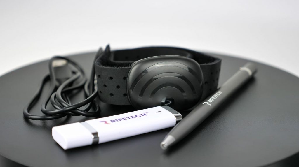 L Rifentech Plasma Schwarzes Armbandgerät mit Kabel sowie zwei Handgeräte mit Aufschrift RIFETECH® auf Tisch